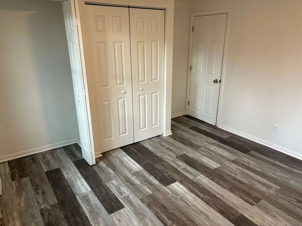 Renovated room with plank flooring and white closet doors