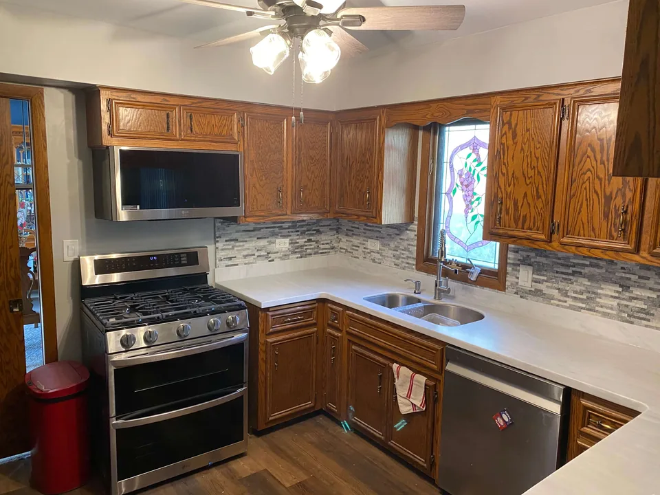 Remodeled kitchen with wood cabinets and a tiled backsplash